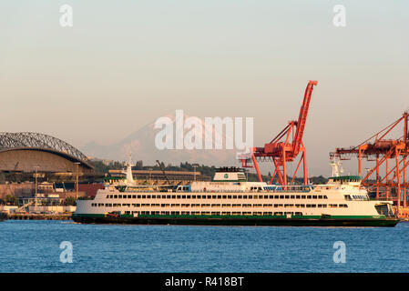 USA, l'État de Washington, Seattle. Lumière du soir comme Seattle Bainbridge ferry part avec Mt. Rainier arrière-plan. Banque D'Images