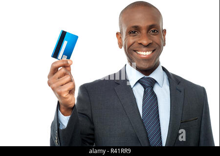 Smiling guy montrant une carte de crédit d'entreprise Banque D'Images