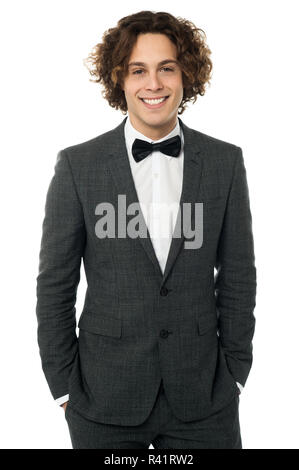 Elegant man in tuxedo posing over white Banque D'Images