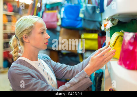 Blonde woman shopping for Casual Sac en cuir. Banque D'Images