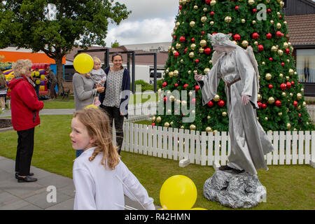 Rangiora, Nouvelle-Zélande - 23 novembre 2018 : un artiste de rue de divertir les gens en face d'un arbre de Noël décoré Banque D'Images