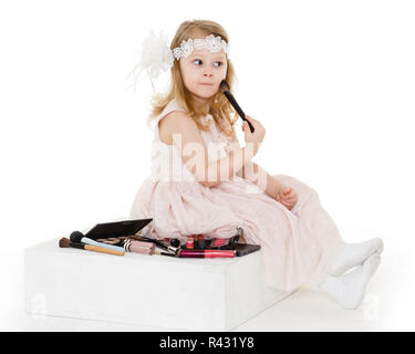 Petite fille jouant avec les cosmétiques. Banque D'Images