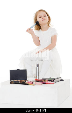 Petite fille jouant avec les cosmétiques. Banque D'Images