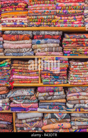 Foulards colorés affiche soigneusement pliés sur des étagères, prête pour la vente dans un bazar. Banque D'Images