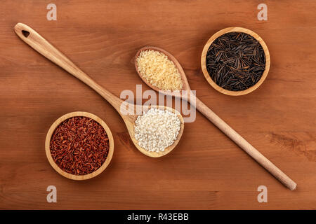 Une photo prise à la verticale de rouge à grains de riz de Camargue, le riz de la paella blanc appelé bomba, le riz étuvé, riz noir sauvage et, tourné par le haut sur une ru Banque D'Images