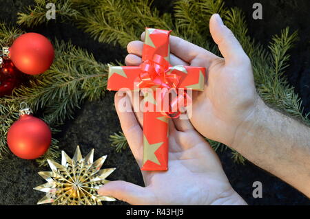 Mains donner loin un encadré en papier de cadeau de noël croix Banque D'Images