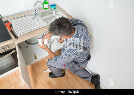 Fixation du tuyau plombier lavabo dans la cuisine Banque D'Images