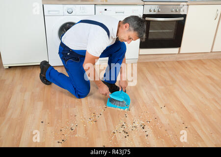 Concierge Balayer étage avec une pelle et brosse dans la cuisine Banque D'Images