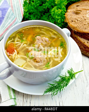 Soupe avec des boulettes de viande et les nouilles dans un bol sur light board Banque D'Images