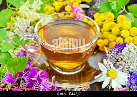 Fleurs de thé dans le verre tasse sur conseil sombre Banque D'Images