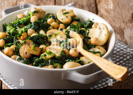 L'alimentation végétarienne saine de pois chiches aux épinards et champignons close-up dans un bol sur la table horizontale. Banque D'Images