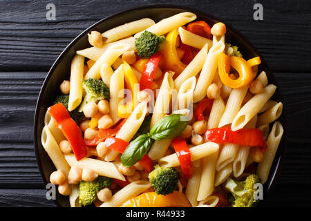 Close-up de l'alph pâtes penne avec les pois chiches, le brocoli, le poivron et les épices dans une assiette sur la table. haut horizontale Vue de dessus Banque D'Images