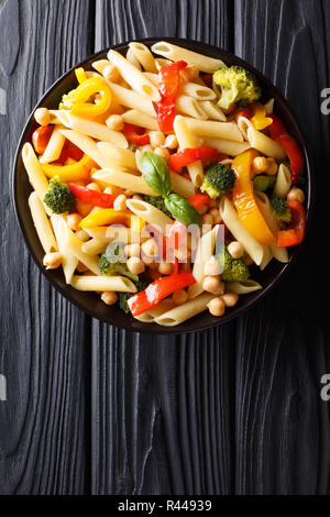 Pâtes penne avec les pois chiches, le brocoli, le poivron et les épices close-up dans une assiette sur la table. Haut Vertical Vue de dessus Banque D'Images