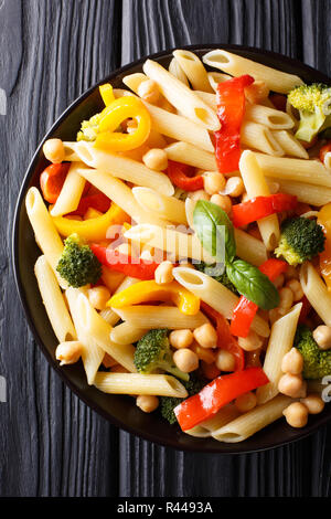 Close-up de l'alph pâtes penne avec les pois chiches, le brocoli, le poivron et les épices dans une assiette sur la table. Haut Vertical Vue de dessus Banque D'Images