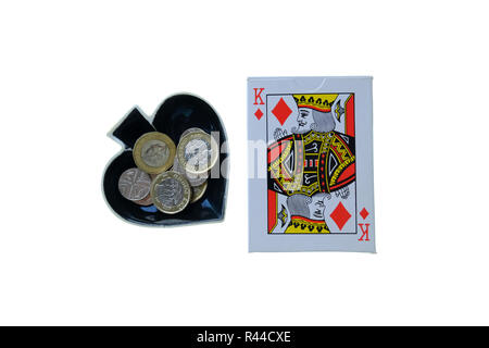 Pack de cartes à jouer traditionnelles sur fond blanc avec des as de pique breloque en forme de bol sur le côté avec le changement lâche en elle. Banque D'Images