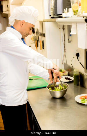 Male chef occupé à donner une touche finale à la fiche recette Banque D'Images