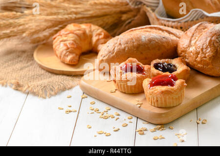 Du pain fait maison avec des fruits, Danois, sauce aux cerises sur fond de bois blanc, le petit déjeuner d'un concept Banque D'Images