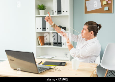 Les gens d'affaires, les imbéciles et fun concept - portrait of caucasian man stretching bubble gum de la bouche in office Banque D'Images