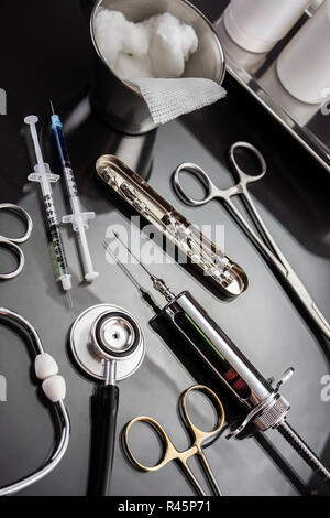 Des ciseaux et des seringues pour une table de salle d'opération d'un hôpital, conceptual image Banque D'Images