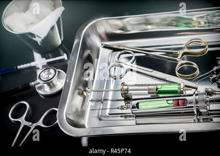 Des ciseaux et des seringues pour une table de salle d'opération d'un hôpital, conceptual image Banque D'Images