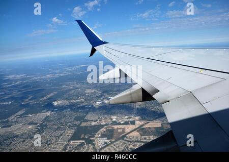 Vue de l'extension, les nuages et la terre au-dessous d'une fenêtre de l'avion de Delta Airlines au départ de Houston, Texas, USA. Banque D'Images