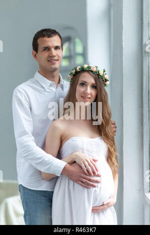 Cheerful young couple habillé en blanc à domicile permanent Banque D'Images