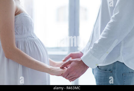 Le jeune couple habillé en blanc à domicile permanent Banque D'Images