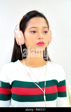 Beautiful woman posing - écoute la musique au casque, portrait de femme triste Banque D'Images
