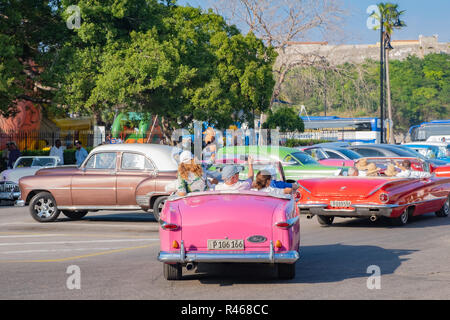 Les touristes profitent de l'occasion de rouler dans une voiture américaine vintage au centre-ville de La Havane à Cuba. Banque D'Images