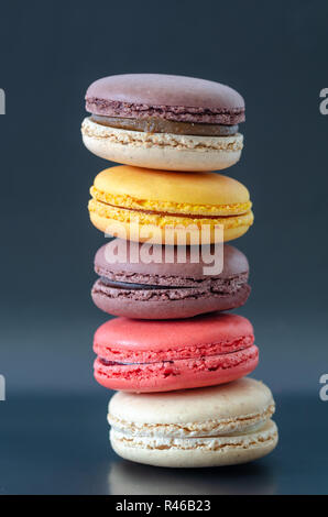 Macarons colorés sont sur le fond sombre, Banque D'Images