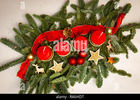 Une couronne avec quatre bougies rouges et décorations de Noël Banque D'Images