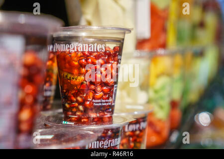 Close up de tasse en plastique avec graines de grenade rouge vif Banque D'Images