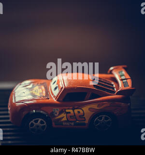 Petite voiture rouge jouet dans la lumière vive Banque D'Images