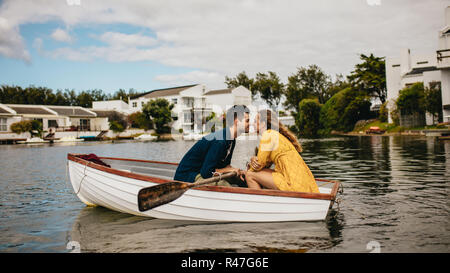 Jeune couple sur une date assis dans un bateau. Couple amoureux assis dans un bateau en face de l'autre. Banque D'Images