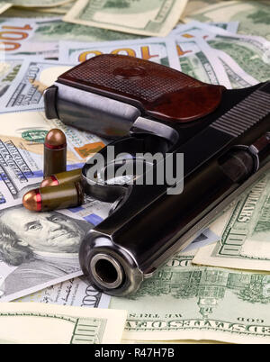 Un pistolet avec des balles sur les billets de dollars américains. Banque D'Images