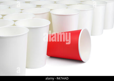 Il y a un rouge et un grand nombre de tasses de papier blanc vide isolé sur fond blanc. Le livre blanc tasses sont sur la diagonale de l'image, la tasse rouge est parmi eux. Banque D'Images