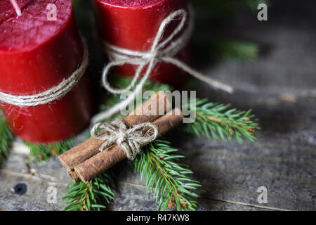 Fond d'hiver avec des branches de sapin, des bougies et des bâtons de cannelle sur planche de bois. Noël et Nouvel An carte de vœux. Banque D'Images