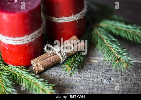 Fond d'hiver avec des branches de sapin, des bougies et des bâtons de cannelle sur planche de bois. Noël et Nouvel An carte de vœux. Banque D'Images