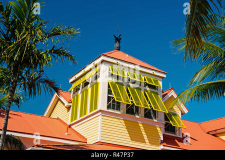 Avec mansarde fenêtres jaune ouvert et l'ananas sur le toit en terre cuite journée ensoleillée sur ciel bleu à Nassau, Bahamas. Architecture, bâtiment, structure Banque D'Images