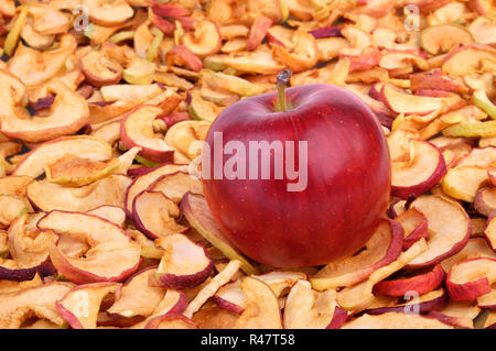L'un venu pomme rouge posé sur une grande quantité de pommes séchées. Banque D'Images
