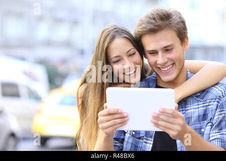 Heureux Couple partageant une tablette dans la rue Banque D'Images