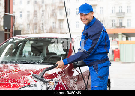 Travailleur manuel lave-voiture à la station-service Banque D'Images