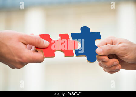 Les hommes d'adhérer à des morceaux de puzzle Banque D'Images