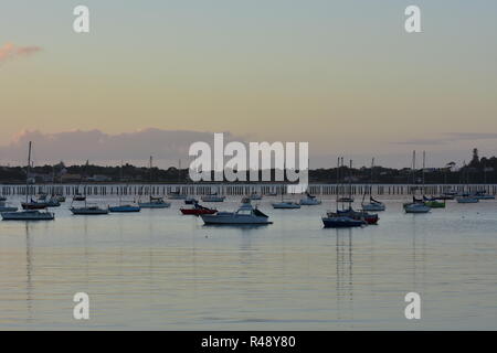 Voiliers sur les ancrages dans Okahu Bay à Auckland après le coucher du soleil sur la journée calme. Banque D'Images