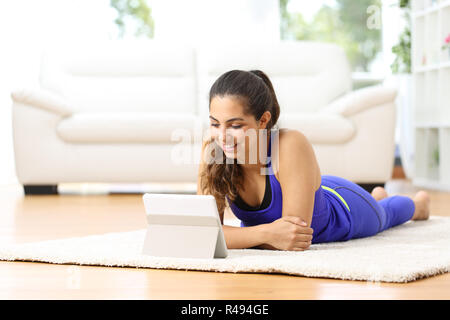 Sportswoman regarder les sports vidéos dans un comprimé Banque D'Images