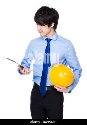 Jeune ingénieur en attente avec casque de protection et du presse-papiers Banque D'Images