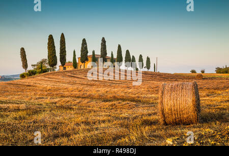 Beau paysage Toscane traditionnelle avec maison de ferme et bottes de foin dans la lumière du soir d'or, Val d'Orcia, Italie Banque D'Images