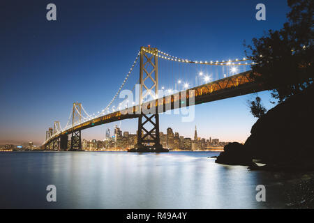 L'affichage classique de l'horizon de San Francisco avec le célèbre Oakland Bay Bridge illuminée en beau crépuscule du soir au crépuscule en été, San Francisco Banque D'Images