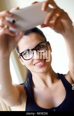 Cute brunette woman taking photo of herself Banque D'Images