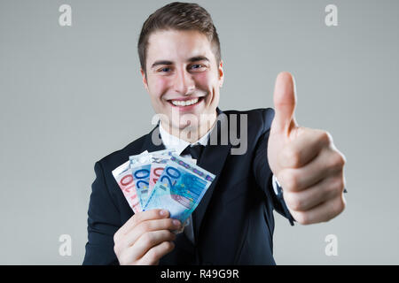 Jeune homme dans la soirée de la détention de monnaie. Banque D'Images